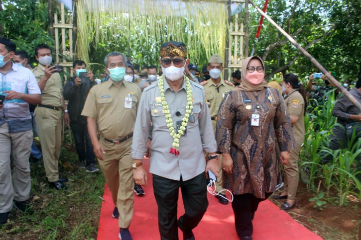 Mentan Syahrul Yasin Limpo (tengah) berjalan bersama Bupati Sragen Kusdinar Untung Yuni Sukowati saat memasuki areal panen kacang tanah di Desa Bendungan, Kedawung, Sragen, Senin (10/1/2022). (Solopos.com/Tri Rahayu)