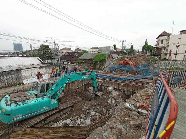 Ekskavator dioperasikan untuk pengerukan tanah sebagai persiapan memasang abutmen pembangunan overpass Jl DI Pandjaitan, Solo, Minggu (16/1/2022). (Solopos/Bayu Jatmiko Adi)