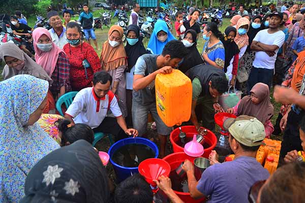 Warga antre membeli minyak goreng curah saat operasi pasar minyak goreng curah di Lapangan Desa Megawon, Kudus, Jawa Tengah, Rabu (20/4/2022). Operasi pasar yang digelar pemerintah desa setempat itu menyediakan sebanyak 8.000 liter bagi masyarakat umum dengan harga lebih murah dari pasaran yakni Rp14 ribu per liter guna meringankan beban masyarakat jelang lebaran. ANTARA FOTO/Yusuf Nugroho/wsj.