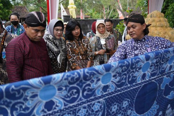 Wakil Menteri Desa Pembangunan Daerah Tertinggal dan Transmigrasi Budi Arie Setiadi (kiri) bersama Wakil Direktur Utama BNI Adi Sulistyowati (kedua dari kiri) melihat kain batik di gerai Lidiah Art saat peluncuran Galeri Ekonomi dan Investasi Desa di Balai Ekonomi Desa Wanurejo, Kecamatan Borobudur, Kabupaten Magelang, Provinsi Jawa Tengah, Kamis (19/5/2022). (Antara/Anis Efizudin)