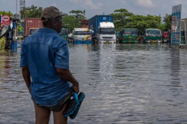Seorang pekerja pelabuhan melihat kondisi banjir limpasan air laut ke daratan atau rob yang merendam kawasan Pelabuhan Tanjung Emas, Semarang, Jawa Tengah, Selasa (24/5/2022). (Antara/Aji Styawan)