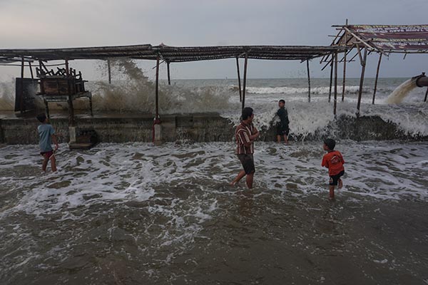 Sejumlah warga berjalan menghindari gelombang air laut di Pesisir pantai Utara, Pekalongan, Jawa Tengah, Senin (23/5/2022). Palang Merah Indonesia (PMI) Kota Pekalongan menghimbau warga sekitar pesisir pantai Utara Pekalongan untuk waspada dengan adanya gelombang laut setinggi sekitar 1-3 meter dan dapat menyebabkan banjir rob. ANTARA FOTO/Harviyan Perdana Putra/rwa.