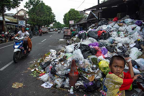 Pengendara melintas di dekat tumpukan sampah di kawasan Lempuyangan, Yogyakarta, Rabu (11/5/2022). Penumpukan sampah di tempat pembuangan sampah sementara kota Yogyakarta tersebut akibat penutupan akses jalan terkait penolakan warga terhadap proses transisi pembuangan sampah ke lahan baru di kawasan Piyungan serta meminta penutupan TPST Piyungan secara permanen. ANTARA FOTO/Hendra Nurdiyansyah/aww.