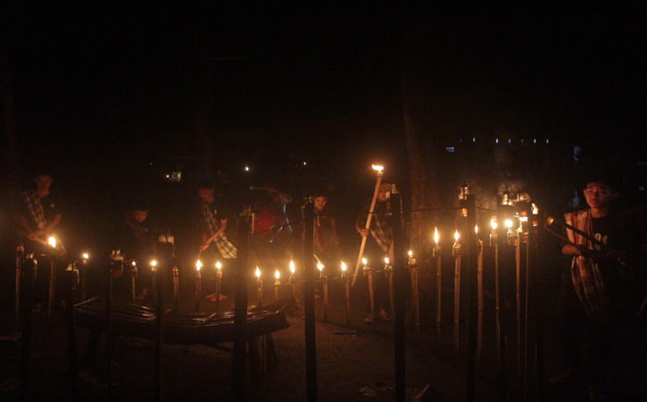 Pasukan obor menyalakan obor ramai-ramai di lokasi swafoto obor cinta di Pasar Kawak Ngasinan Etan, Gebang, Masaran, Sragen, Jumat (6/5/2022) malam. (Solopos-Tri Rahayu)