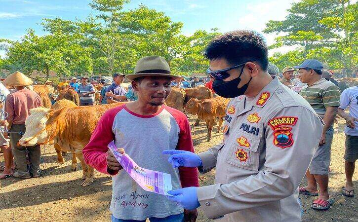 Kapolres Boyolali, AKBP Asep Mauludin (kanan), memberikan penyuluhan terkait penyakit mulut dan kuku (PMK) di Pasar Hewan Karanggede, Minggu (15/5/2022). Saat itu, tim gabungan mengecek hewan ternak di Pasar Hewan Karanggede, Boyolali. (Istimewa/Polres Boyolali)