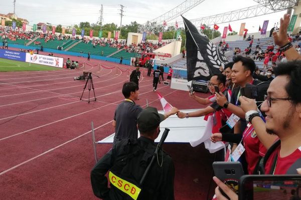 Suporter Indonesia yang berada di Stadion Viet Tri, Phu To, Vietnam, menyampaikan memberikan bendera Merah Putih kepada pelatih Shin Tae-yong seusai tim asuhannya mencukur Filipina 4-0 di laga lanjutan Grup A cabang sepak bola SEA Games 2021, Jumat (13/5/2022). (Antara/Zuhdiar Laeis)