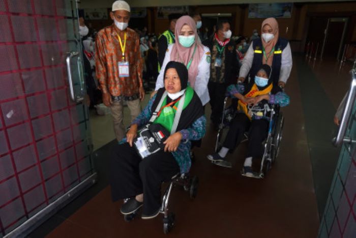 Dua petugas mendorong kursi roda dua calon haji asal Kalimantan Barat embarkasi Batam menuju bus Damri sebelum keberangkatan di Kapuas Palace, Pontianak, Kalimantan Barat, Rabu (15/6/2022). Sebanyak 444 calon haji asal Kalimantan Barat kelompok terbang 1 embarkasi Batam yang telah dinyatakan sehat dan negatif Covid-19 diberangkatkan menuju Arab Saudi melalui Bandara Internasional Supadio Kubu Raya. (Antara/Jessica Helena Wuysang)