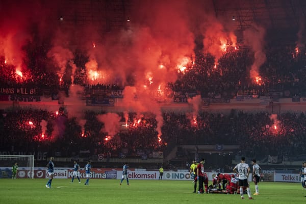 Suporter Persib Bandung menyalakan flare saat pertandingan Group C Piala Presiden 2022 di Stadion Gelora Bandung Lautan Api, Bandung, Jawa Barat, Minggu (12/6/2022). Pertandingan Persib Bandung melawan Bali United FC tersebut berakhir imbang dengan skor 1-1. (ANTARA FOTO/M Agung Rajasa/aww)