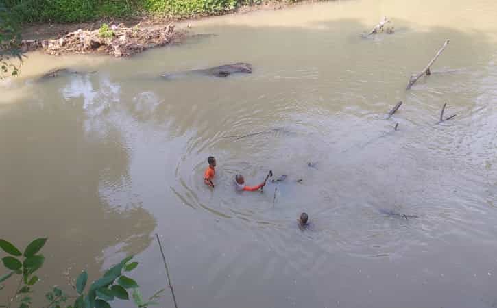 Dua orang warga melakukan pencarian di perairan Sungai Mungkung wilayah Kelurahan Karangtengah, Sragen Kota, Sragen, Minggu (26/6/2022). (Istimewa/Galih Setyo Nugroho)