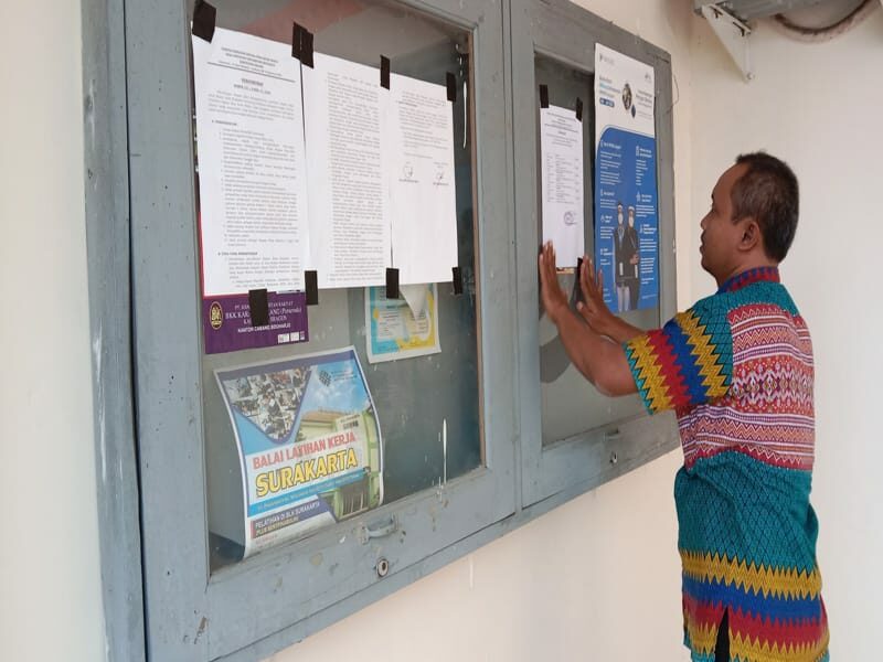 Petugas di Desa Singopadu, Kecamatan Sidoharjo, Kabupaten Sragen memasang pengumuman hasil seleksi administrasi bakal calon dalam pemilihan kepala desa pengganti antar waktu, Selasa (21/6/2022) di balai desa setempat. (Solopos.com/Akhmad Ludiyanto)
