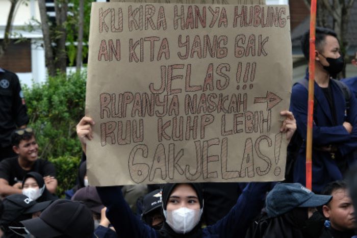 Seorang mahasiswa mengangkat poster bertuliskan protes pada pembahasan Rancangan Kitab Undang-undang Hukum Pidana (RKUHP). Ia dan mahasiswa lainnya berdemonstrasi di halaman Gedung DPRD Provinsi Kalimantan Barat, Kota Pontianak, Kalimantan Barat, Rabu (6/7/2022). Mereka menuntut pemerintah dan DPR membuka draf RKUHP karena mengandung banyak pasal bermasalah yang merugikan publik. (Antara/Jessica Helena Wuysang)