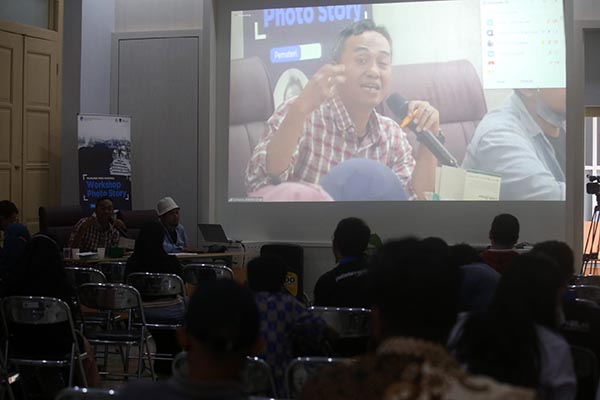 Dosen Program Studi Fotografi Institut Seni Indonesia (ISI) Solo Andry Prasetyo terlihat di layar saat memberikan materi dalam Workshop Photo Story di Monumen Pers Solo, Senin (4/7/2022). (Solopos/Nicolous Irawan)