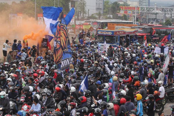 Suporter Arema FC yaitu Aremania melakukan konvoi di pintu keluar jalan tol Malang-Pandaan di Karanglo, Malang, Jawa Timur, Senin (18/7/2022), untuk menyambut kedatangan tim Arema FC yang menjuarai Piala Presiden 2022. (Antara/Ari Bowo Sucipto)