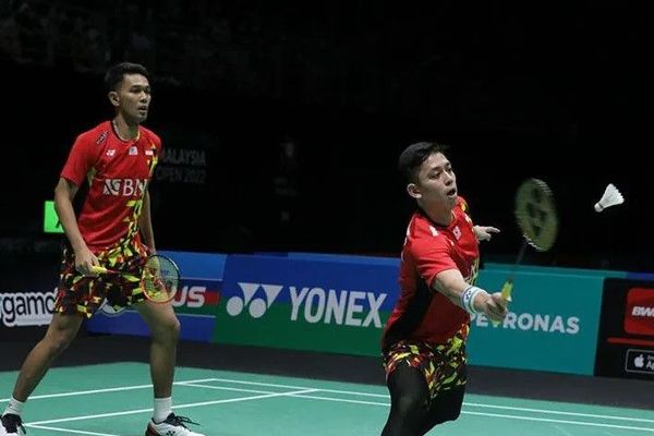 Fajar Alfian (kiri) dan Muhammad Rian Ardianto memukul kok ke arah ganda putra Malaysia, Ong Yew Sin/Teo Ee Yi di babak perempat final turnamen bulu tangkis Malaysia Open 2022, Jumat (1/7/2022) di Kuala Lumpur, Malaysia. (Antara/HO-PBSI)