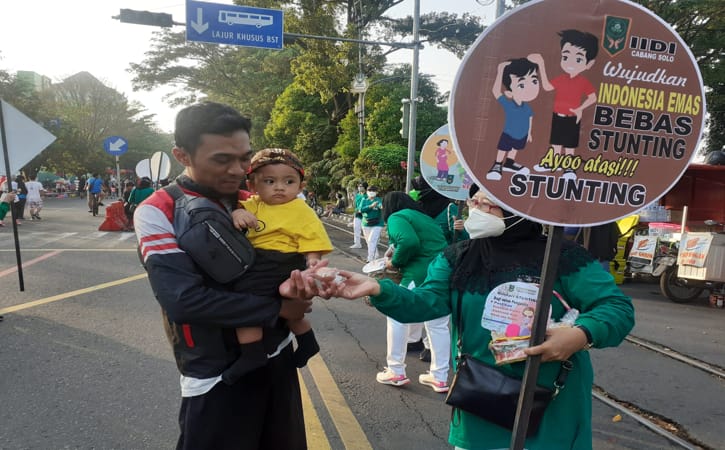 Belasan wanita istri dokter membagikan telur kepada anak-anak di sepanjang Car Free Day Solo mulai dari Persimpangan Sriwedari hingga Gendengan, Minggu (3/7/2022). (Solopos/Siti Nur Azizah)