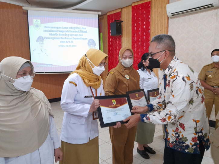 Group Head II Program Pengendalian Gratifikasi KPK, Sugiarto (kanan), menyerahkan piagam pencanangan zona integritas kepada perwakilan kepala puskesmas di Aula Sukowati Setda Sragen, Senin (25/7/2022). (Solopos.com/Tri Rahayu)