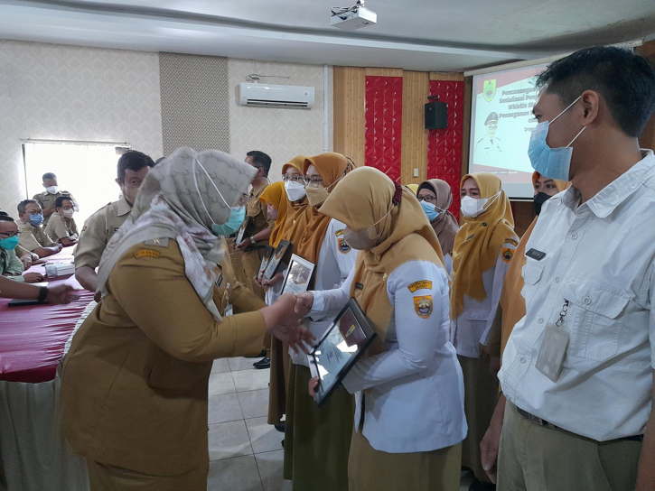 Bupati Sragen Kusdinar Untung Yuni Sukowati menyerahkan piagam zona integritas kepada perwakilan kepala puskesmas di Aula Sukowati Setda Sragen, Senin (25/7/2022). (Solopos.com/Tri Rahayu)