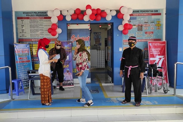 Pemohon SIM dilanyani anggota Satlantas Polres Grobogan yang mengenakan baju adat dalam rangka HUT ke-77 RI, Selasa (16/8/2022). (Istimewa/Satlantas Grobogan)