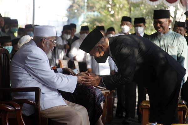 Menko PMK Muhadjir Effendy (kanan) bersalaman dengan pendiri Pondok Pesantren Islam Al Mukmin Ngruki Abu Bakar Ba'asyir (kiri) saat upacara HUT ke-77 RI di ponpes setempat, Ngruki, Sukoharjo, Jawa Tengah, Rabu (17/8/2022). (Antara/Maulana Surya)