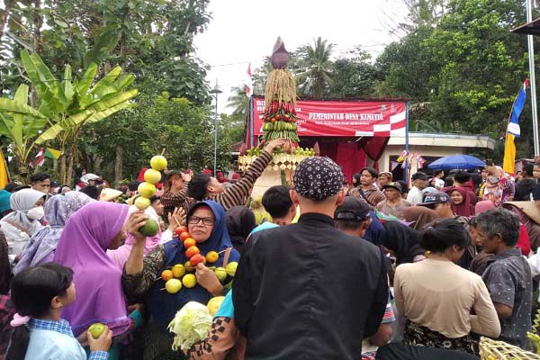 Warga Desa Kemetul, Kecamatan Susukan, Kabupaten Semarang, berebut tumpengan dalam pawai Jolen yang digelar sebagai tradisi merti desa, Sabtu (13/8/2022). (Solopos.com-Hawin Alaina)