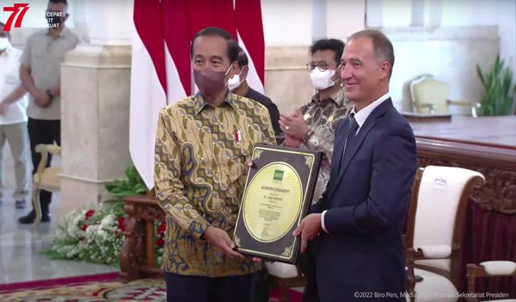 Direktur Jenderal IRRI Jean Balie menyerahkan penghargaan swasembada beras kepada Presiden Joko Widodo (Jokowi) di Istana Negara Jakarta, Minggu (14/8/2022). (Istimewa/Setkab)