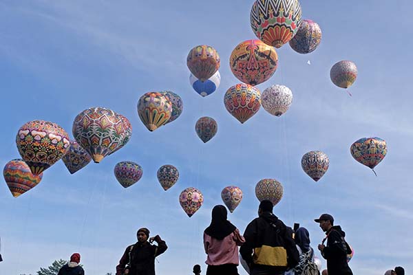 Warga menyaksikan penerbangan balon tradisional saat digelar Java Balloon Attraction di lapangan Taman Rekreasi Kalianget, Wonosobo, Jawa Tengah, Minggu (4/9/2022). Atraksi penerbangang balon tradisional diikuti oleh 25 balon unik dan tiga balon khusus dengan membentuk formasi Gunung Sindoro, Telaga Menjer, Waduk Wadaslintang dan Gunung Prau yang merupakan ikon wisata alam yang ada di kabupaten Wonosobo. ANTARA FOTO/Anis Efizudin/foc.