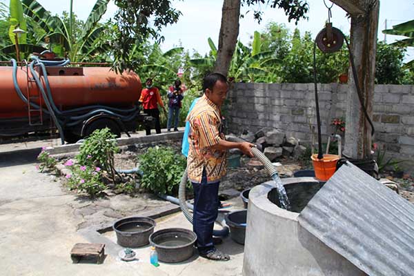 Petugas dari BPBD Klaten mengisi sumur warga saat penyaluran air bersih di Jambakan, Bayat, Klaten, Selasa (27/9/2022). (Solopos/Taufiq Sidik Prakoso)