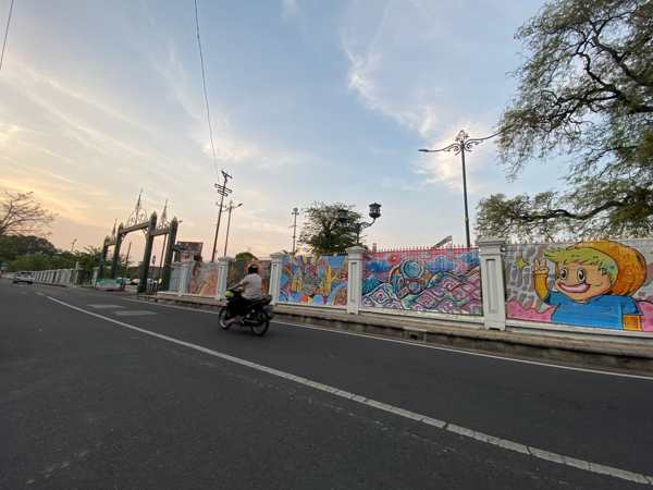 Kerai bambu bergambar mural menutup pagar besi Pamedan Pura Mangkunegaran Solo untuk menyambut Solo Batik Musik Festival atau Sobat Fest, 1-2 Oktober mendatang. Foto diambil Rabu (28/9/2022). (Solopos/Afifa Enggar Wulandari)