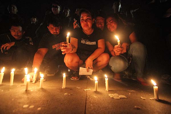 Suporter Persis Solo terlihat menangis ketika menyalakan lilin saat mengikuti aksi solidaritas di kompleks Plaza Manahan, Solo, Minggu (2/10/2022) malam. (Solopos/Nicolous Irawan)