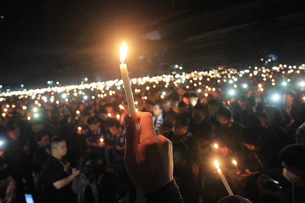 Ribuan suporter klub sepak bola berkumpul dan menyalakan lililn saat doa bersama tragedi Kanjuruhan di Stadion Mandala Krida, Yogyakarta, Selasa (4/10/2022) malam. (Antara/Kalandra)