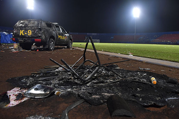 Sebuah mobil polisi berada di pinggir lapangan pascakerusuhan di Stadion Kanjuruhan, Malang, Jawa Timur, Minggu (2/10/2022). Kerusuhan yang terjadi di stadion tersebut menyebabkan 13 unit mobil rusak, 10 unit diantaranya mobil polisi dan tiga unit mobil pribadi. ANTARA FOTO/Zabur Karuru/nym.
