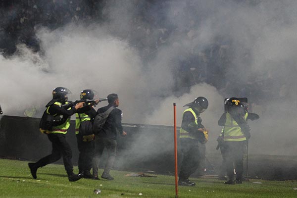 Aparat keamanan menembakkan gas air mata untuk menghalau suporter yang masuk lapangan usai pertandingan sepak bola BRI Liga 1 antara Arema melawan Persebaya di Stadion Kanjuruhan, Malang, Sabtu (1/10/2022). (Antara/Ari Bowo Sucipto)
