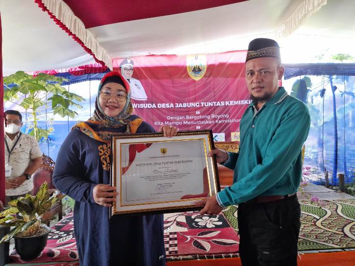 Bupati Sragen, Kusdinar Untung Yuni Sukowati, menyerahkan sertifikat kepada Kepala Desa Jabung Triyono dalam Wisuda Desa Jabung Tuntas Kemiskinan di Dukuh Soko, Desa Jabung, Kecamatan Plupuh, Sragen, Jumat (7/10/2022). (Solopos.com/Tri Rahayu)