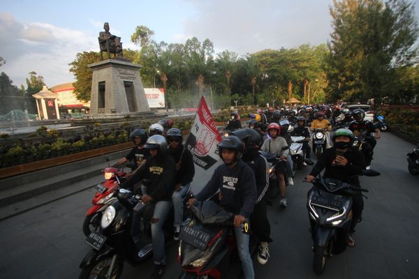 Suporter Persis Solo dengan menggunakan moda sepeda motor berangkat ke Kota Jogja dari Plaza Manahan, Solo, Selasa (4/10/2022). Sejumlah elemen suporter Persis Solo yakni Pasoepati, Surakartans, Ultras 1923, dan Garis Keras Sambernyawa berangkat menuju Kota Jogja untuk memenuhi undangan Brajamusti dan suporter Jogaj untuk doa bersama bagi suporter Aremania yang menjadi korban tragedi di Stadion Kanjuruhan. Melalui momentum tersebut tiga suporter besar yakni suporter Persis Solo, suporter PSS Sleman, dan suporter PSIM Jogja berdamai mengakhiri konflik rivalitas yang selama ini terjadi. (Solopos.com/Nicolous Irawan)